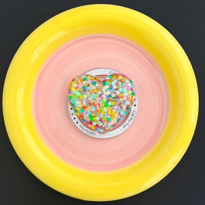Close-up of heart-shaped MagSafe phone grip with colorful glitter sequins on a gift card