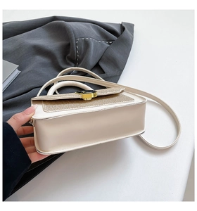 Vista laterale della borsa beige bicolore con trama intrecciata e chiusura a girello oro