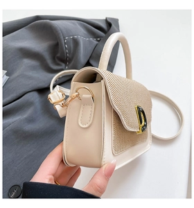 Dettaglio borsa in pelle crema con trama intrecciata e fibbia dorata a forma di D