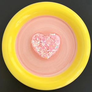 Detailed view of heart-shaped glitter phone stand with pink resin and shiny sequins