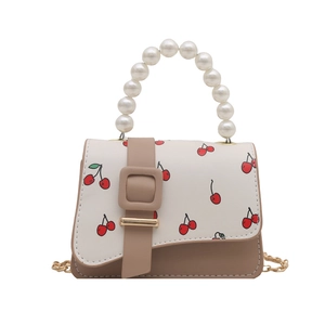 Mini cherry print bag with pearl handle and golden chain strap on a white background