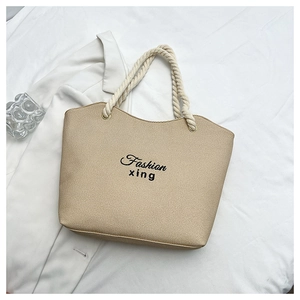 Detail of beige canvas tote bag with cotton rope handles and Fashion xing lettering