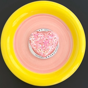 Detail of pink glitter heart MagSafe phone grip with sequins on a decorative stand