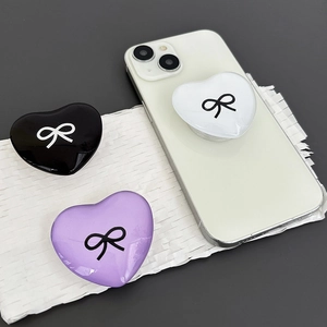 Close-up of heart-shaped phone grip with bowknot design in black, purple and white