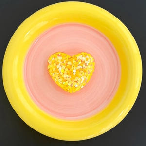 Close-up of heart-shaped phone grip with glitter resin and yellow heart sequins