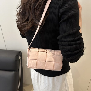 Chic pink woven crossbody bag with snake texture shown on model in a stylish setting