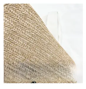 Close-up of beige woven straw tote showing herringbone texture and fine craftsmanship
