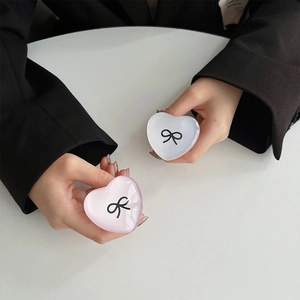 Detail of heart-shaped resin phone grips with ribbon bow design in pink and white