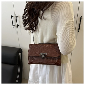 Detail of brown crocodile pattern PU leather crossbody bag with chain and buckle