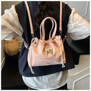 Pink drawstring bucket bag in pleated silk fabric with gold butterfly and pearl handle detail