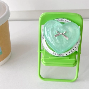 Close-up of mint green heart phone socket with silver bow on a mini green chair