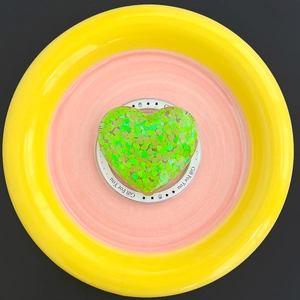 Macro detail of heart-shaped MagSafe phone grip with vibrant neon green glitter sparkles