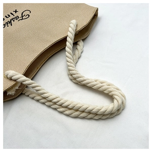 Detail of beige canvas tote with thick white cotton rope handle and Fashion print