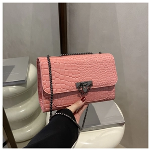 Detail of pink croc-embossed chain bag with grey metal hardware and chic rivet buckle