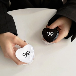 Detail showing heart-shaped phone grips with bow pattern in black and white finish