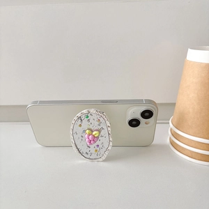 Vue détaillée du support de téléphone raisin violet pailleté sur un smartphone blanc