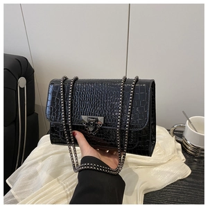 Detail of glossy black crocodile pattern PU leather shoulder bag with metal chain strap