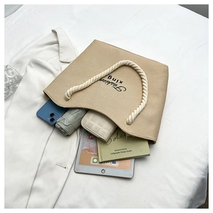 Interior view of beige woven tote bag showing storage capacity for tablet and phone