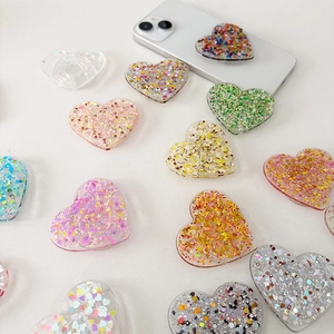 Glittery heart-shaped phone grip sockets in multiple colors on a clean white background