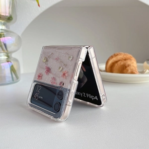 Nahaufnahme der Samsung Z Flip Hülle mit rosa Trockenblumen und silbernem Glitzer-Finish