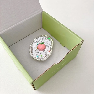 Détail du support de téléphone pêche avec paillettes argentées en boîte verte