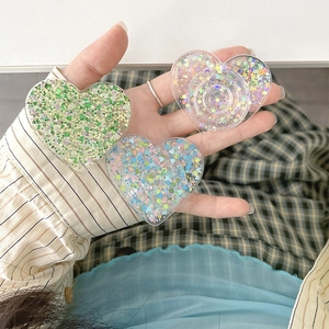 Close-up of heart-shaped glitter phone sockets in green and pink on striped background