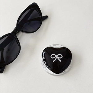 Detail of a black heart phone socket with a white bow pattern on a gift card