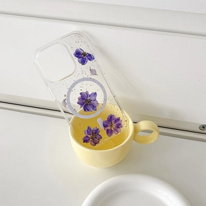 Detail of iPhone case with purple dried flowers, gold flakes, and MagSafe ring in a cup