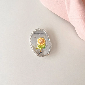 Close-up of yellow flower phone socket with silver mirror base and colorful accents