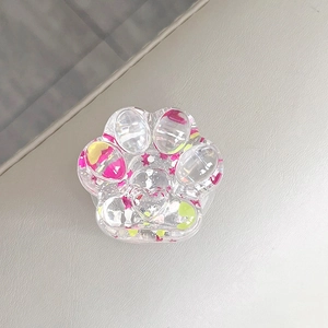 Close-up of a 3D cat paw phone grip with colorful sequins and heart-shaped glitter.