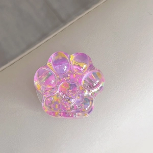 Close-up of a sparkling iridescent sequined cat paw phone grip with a 3D heart detail