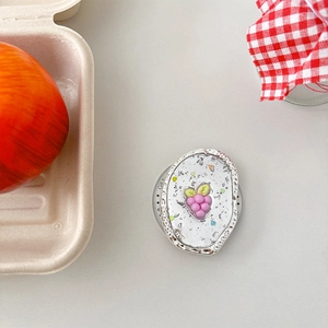 Vue détaillée du support de téléphone avec raisins roses et paillettes scintillantes