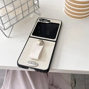 Close-up of woven fabric phone case with finger ring and silver handmade metal plate