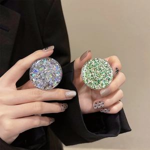 Detail of round glitter phone grip showing sparkling silver and green sequins texture