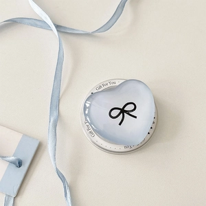 Macro shot of light blue heart phone grip with bow pattern and decorative gift card