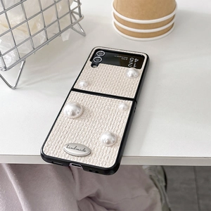 Detail of woven fabric texture with pearls and handmade silver badge on Z Flip phone case