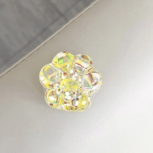 Detailed view of the sparkling glitter sequins inside the yellow resin cat paw phone grip.