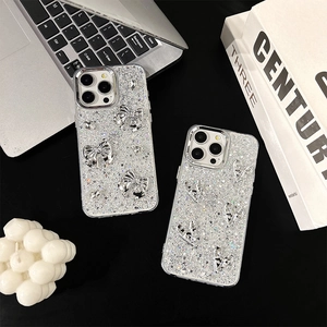 Silver bow and heart glitter phone cases for iPhone on a stylish modern desk