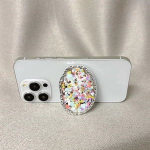 Silver metallic phone grip with heart-shaped colorful sequins on white phone back