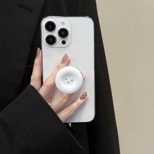 Minimalist white button phone pop socket stand held by a person for a sleek modern look