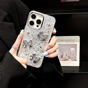 Sparkling silver glitter iPhone case with 3D metal bows and rhinestones held by a model
