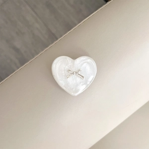 Detailed view of heart phone grip with mother-of-pearl texture and silver bow detail