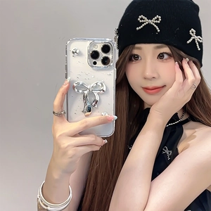Selfie allo specchio con cover iPhone trasparente, fiocco 3D argento e glitter