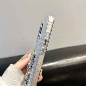 Detail of glitter clear phone case with silver metallic edges and bear kickstand feature