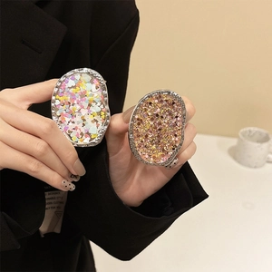 Detailed close-up of metallic irregular phone grip featuring colorful heart sequins decoration