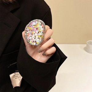 Close-up of oval phone grip with colorful heart sequins and silver metallic border