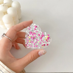Detail of heart-shaped phone grip with pink star sequins and shimmering glitter filling