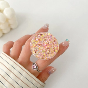 Detail of round glitter phone socket holder with pink sparkles and acrylic finish