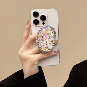 Detail of glitter heart sequins inside an irregular metal phone grip stand