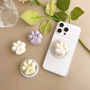 Cute cat paw magnetic phone grip for MagSafe in various pastel colors on a white phone